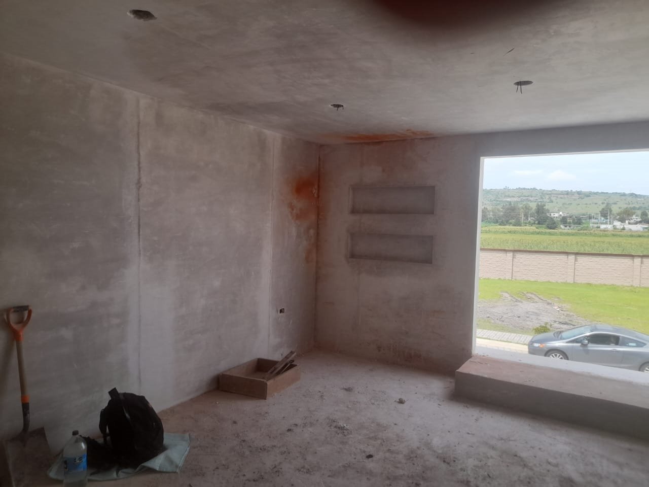 Interior en obra gris, muro con ventana