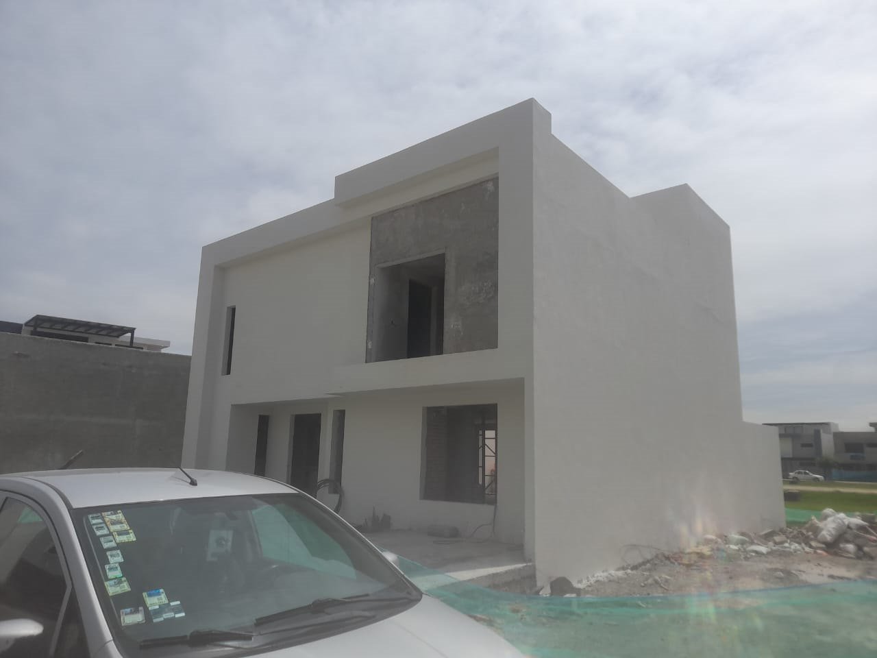 Fachada terminada en obra gris, con acceso