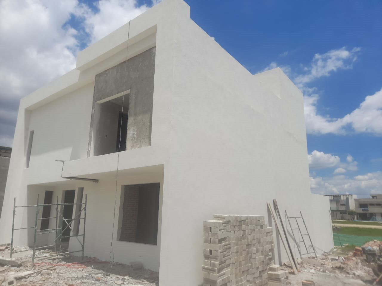 Fachada terminada en obra gris, con ventanería instalada