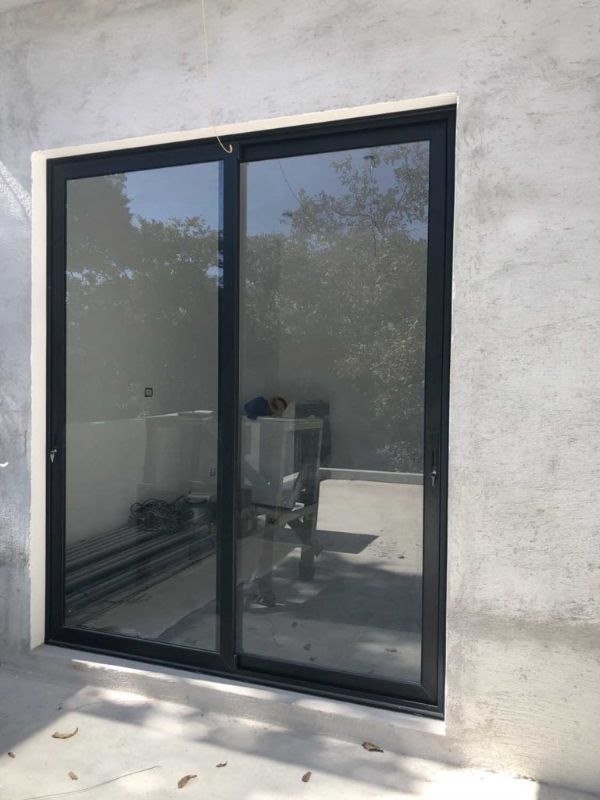 Puerta corrediza de aluminio negro en balcón