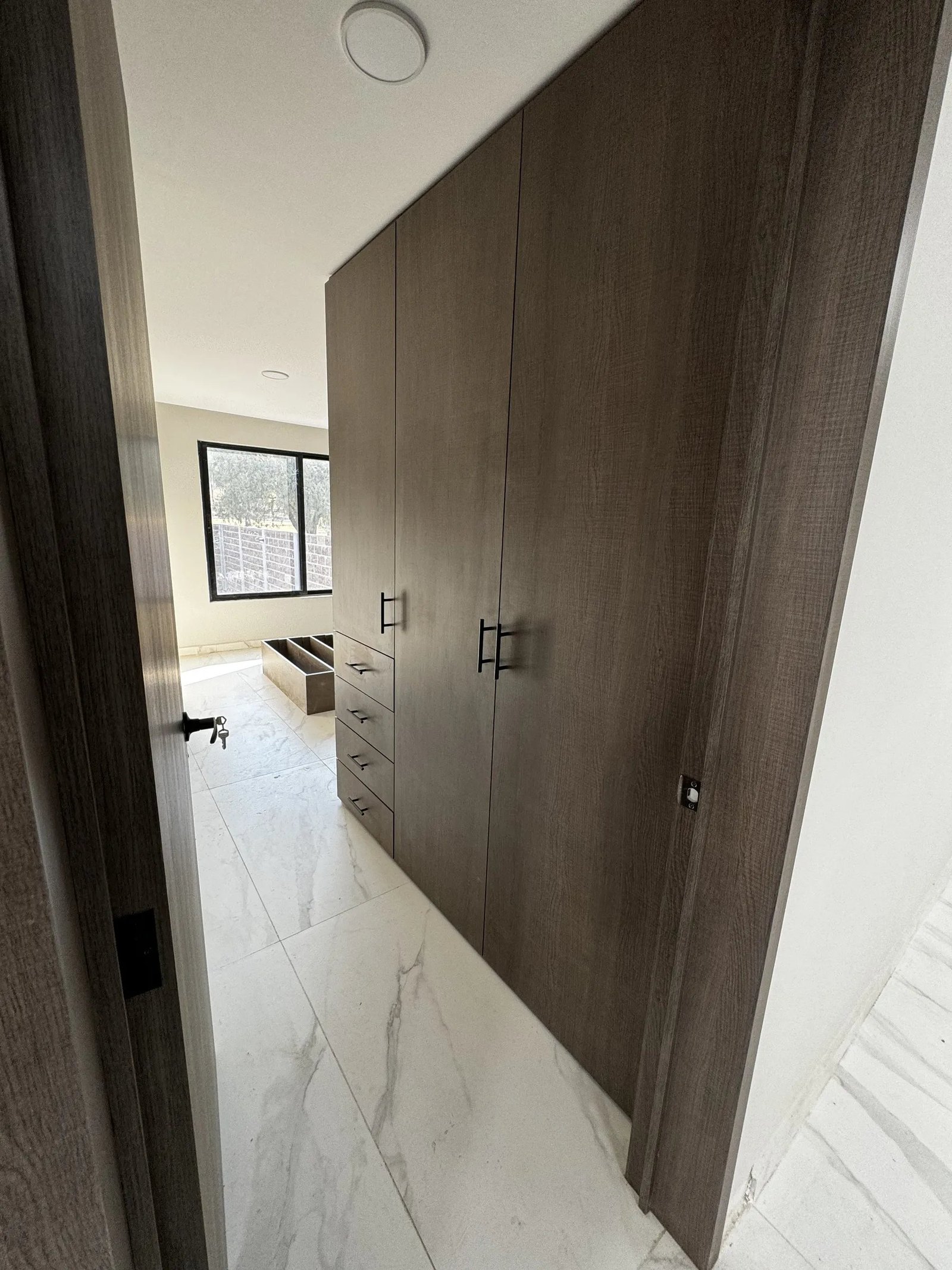 Muro de madera en pasillo con piso de mármol