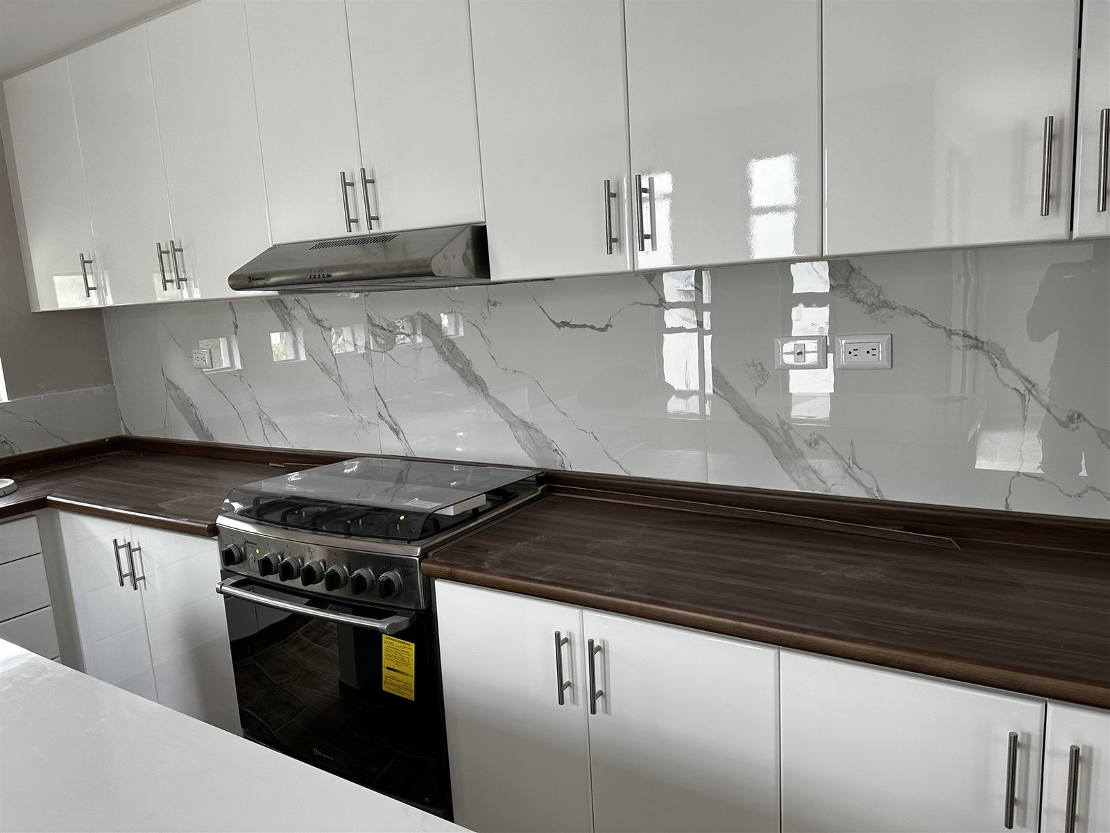 Cocina integral blanca con cubierta de mármol y madera