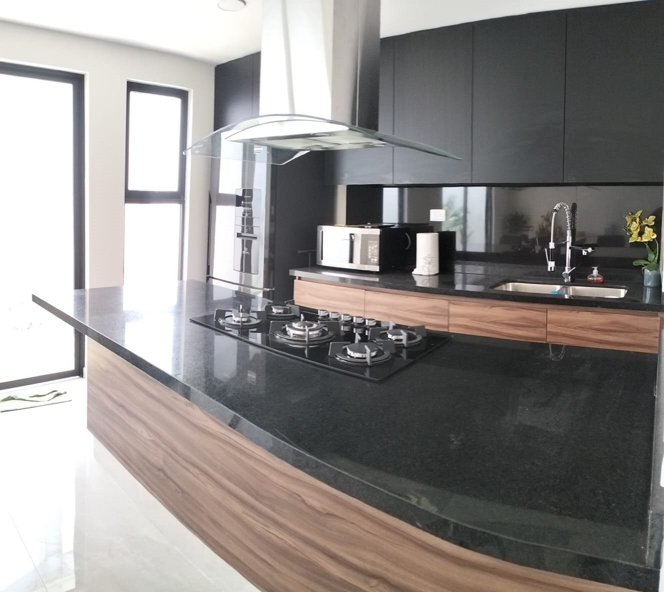Cocina integral en verde oscuro con isla de madera