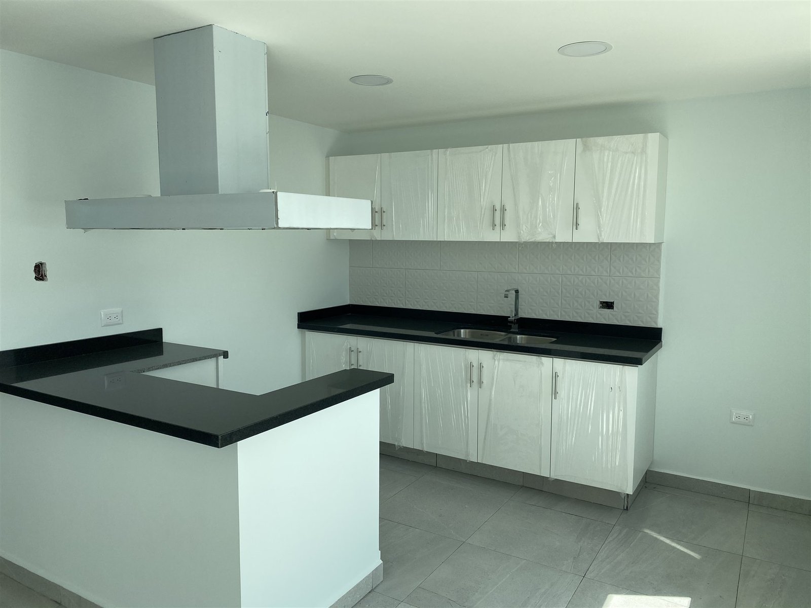 Cocina integral en madera clara con campana de isla
