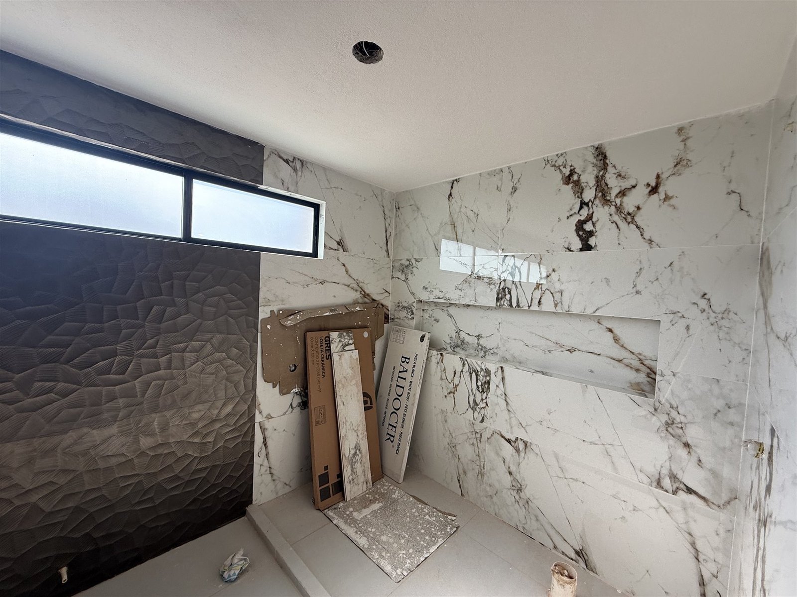 Esquina de baño en mármol con nicho, en proceso