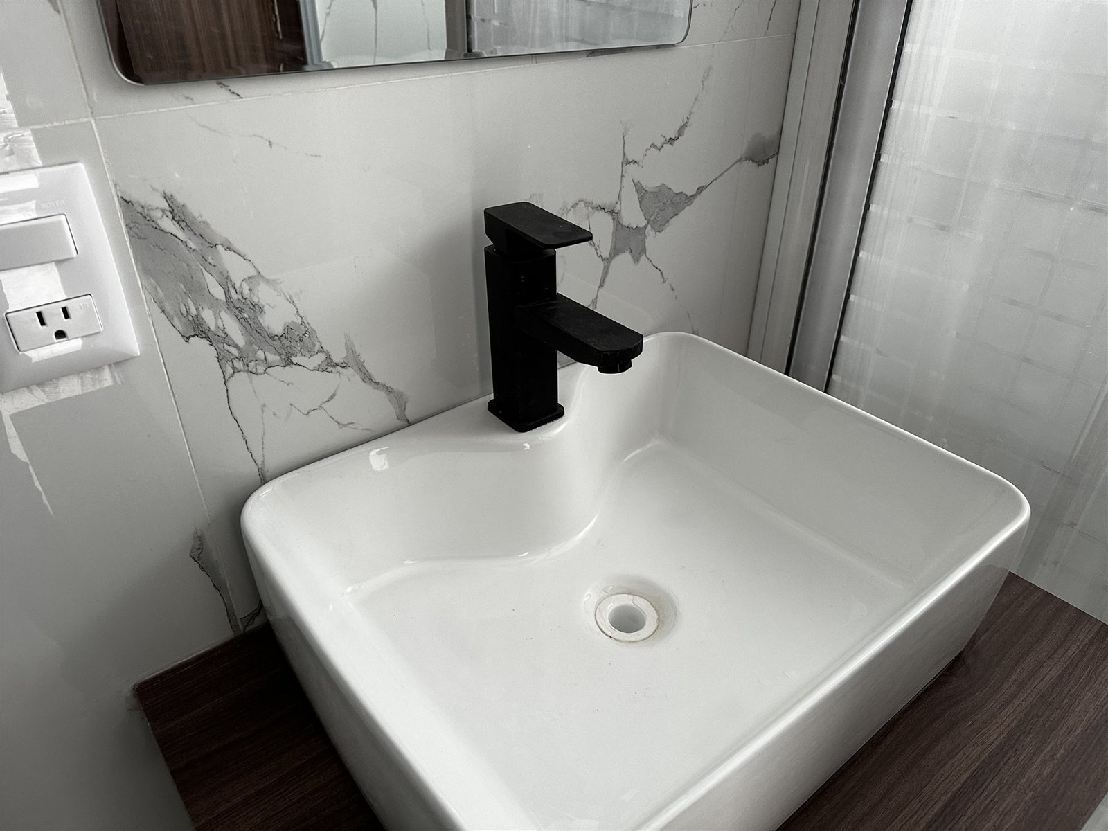 Mueble de baño con ovalín cuadrado sobre mármol