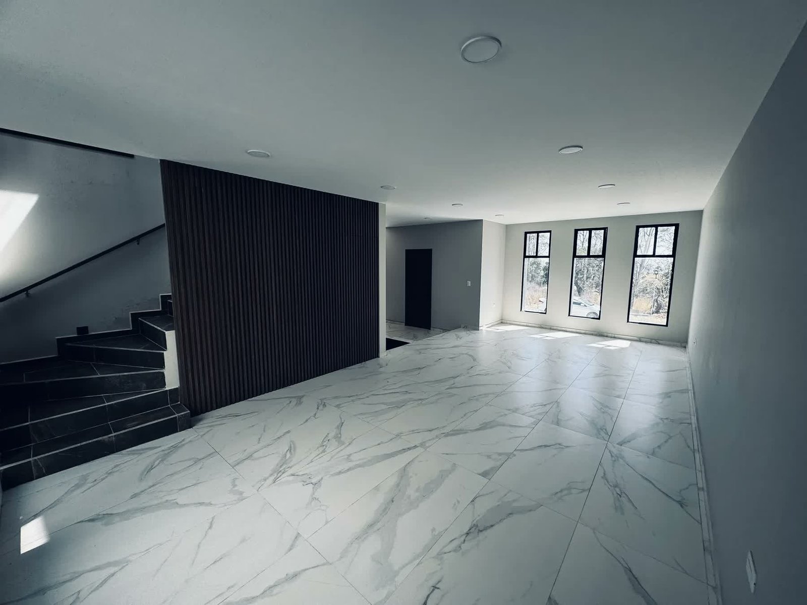 Estancia con escalera y piso de mármol, otro ángulo