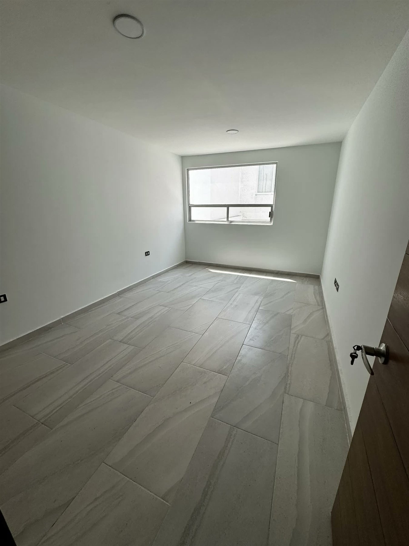 Recámara con piso laminado y luz natural