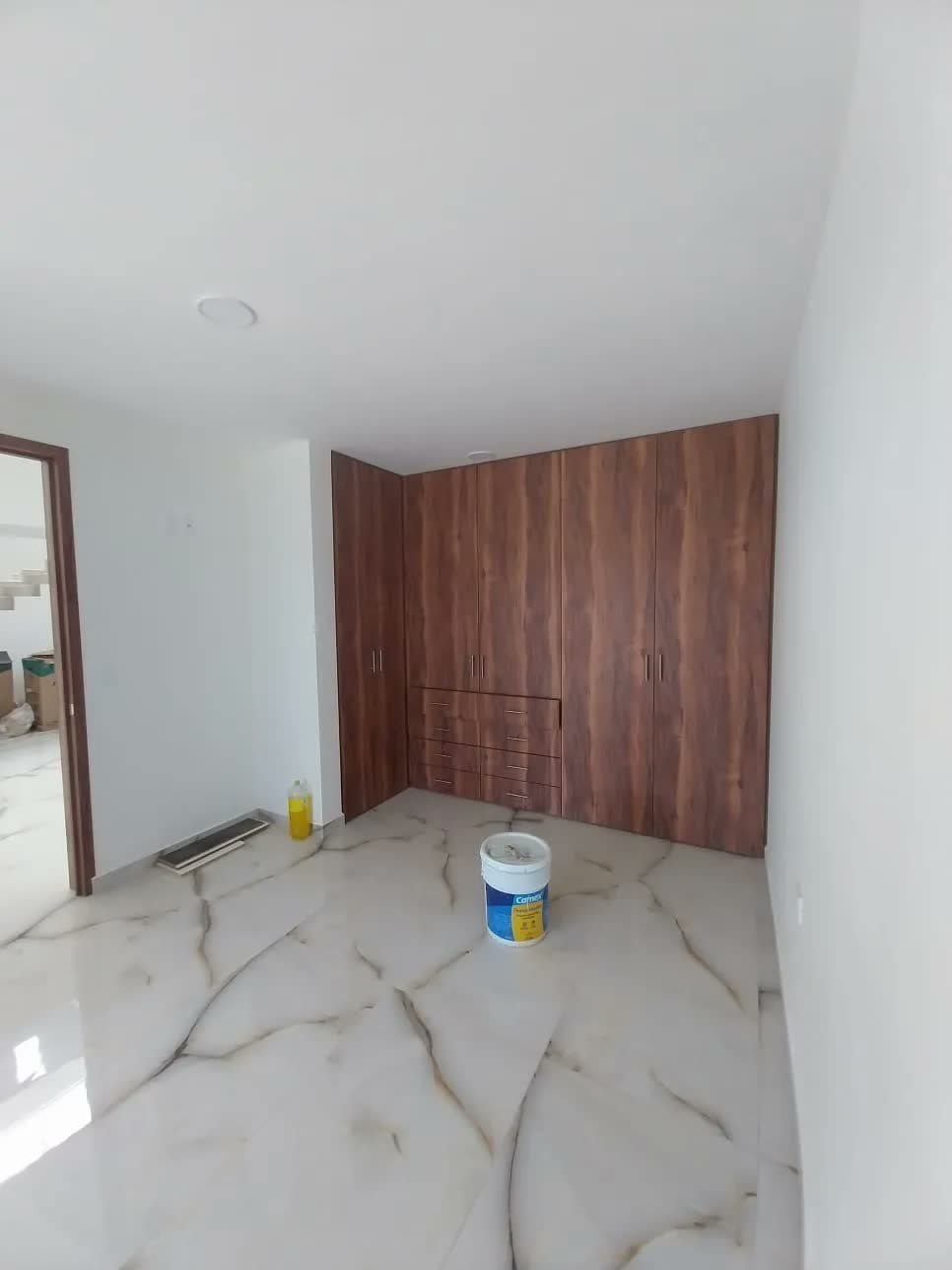 Recámara con piso de mármol y muro de madera