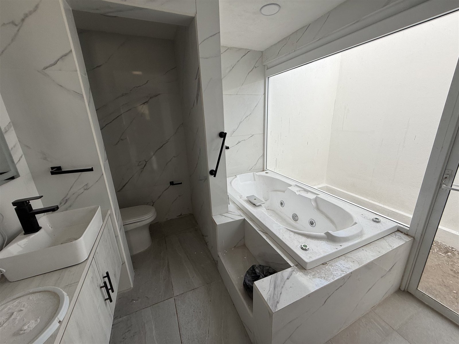 Baño con jacuzzi y ventanal